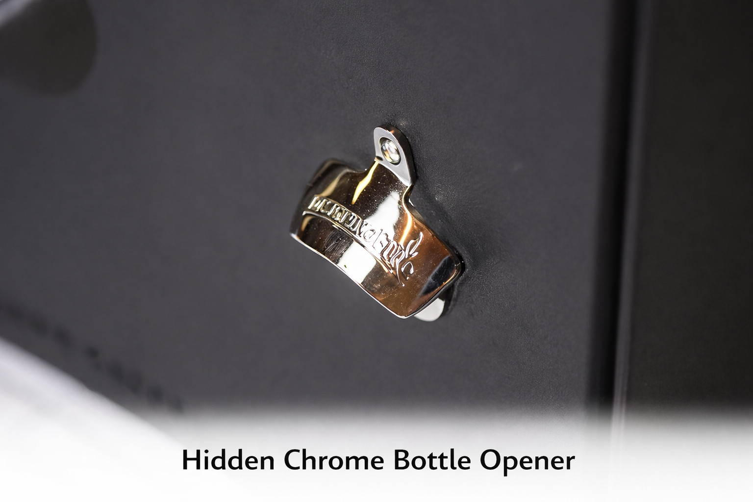 Hidden chrome bottle opener on a black surface with text overlay.